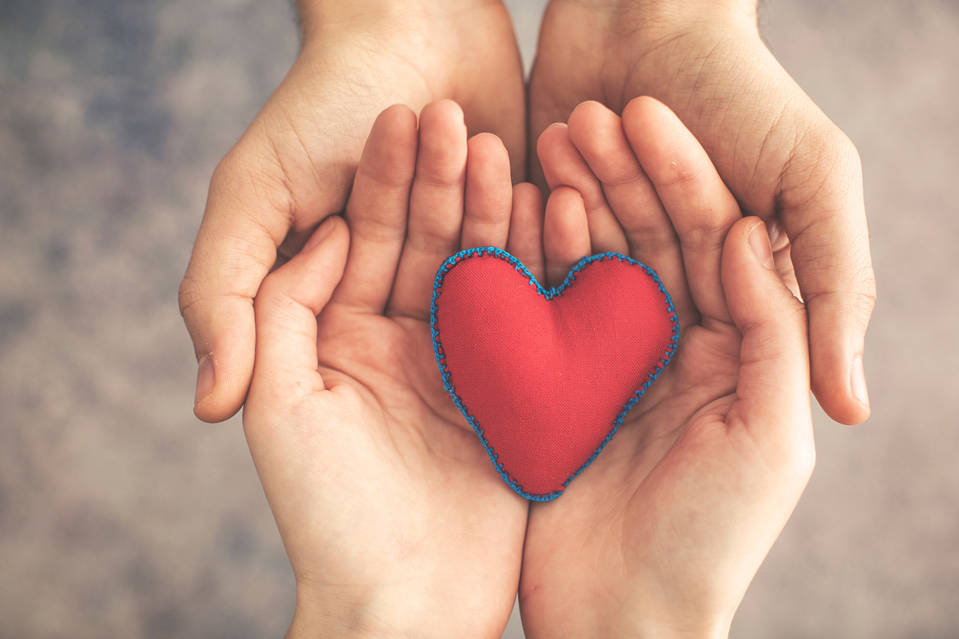 Man and woman hands together with red heart